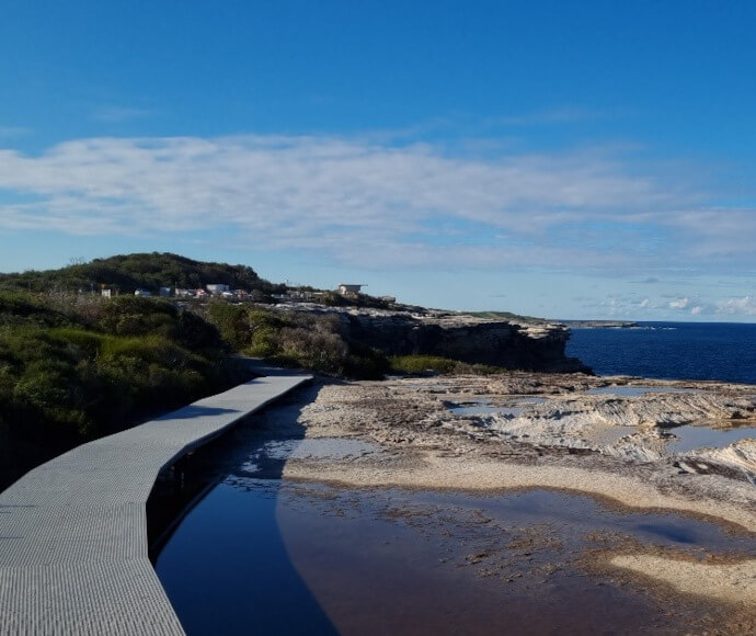 Footbridge section of Cape Baily Walking Track, leading over rockpools by the sea.