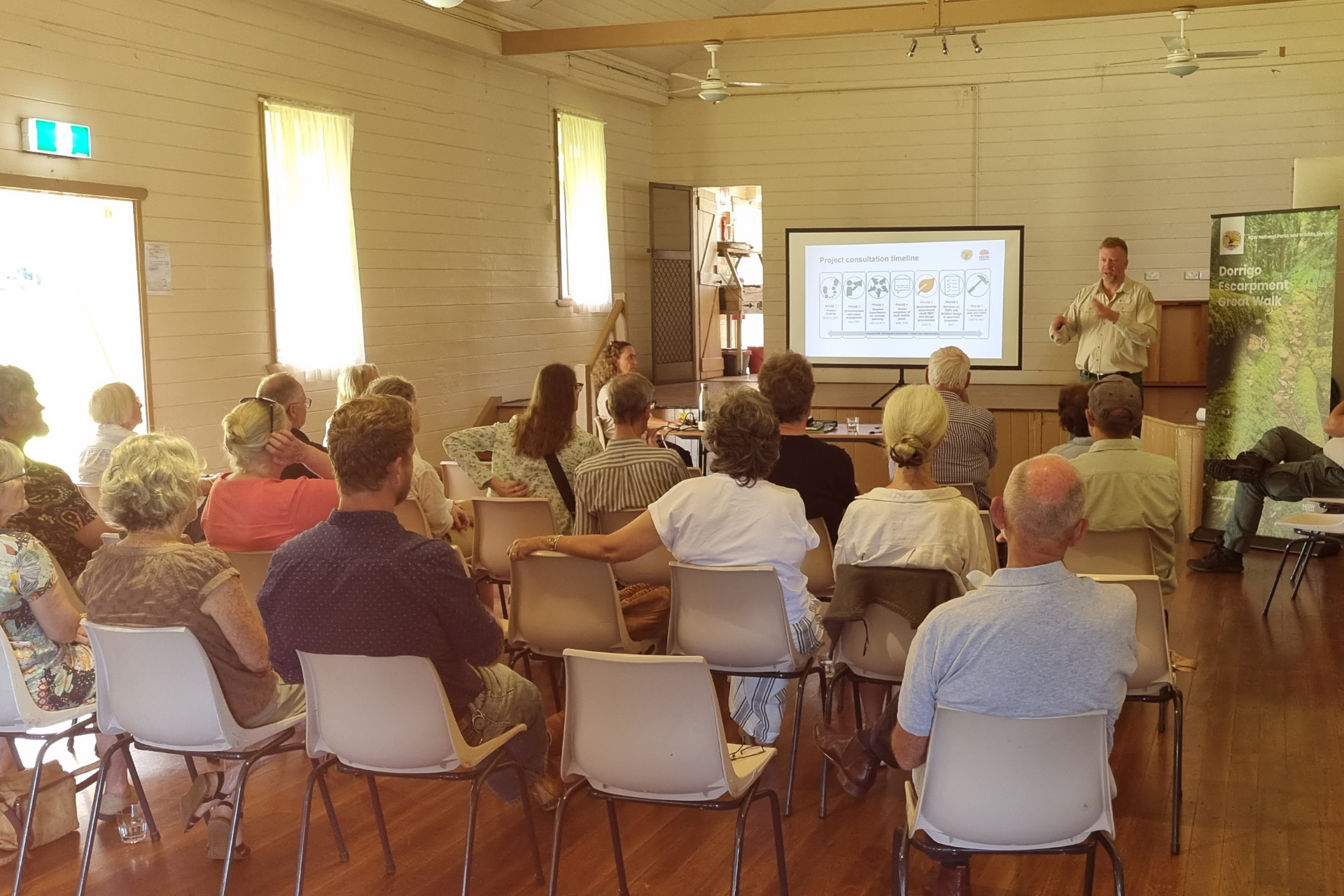 A group of people watching a presentation with a projected screen